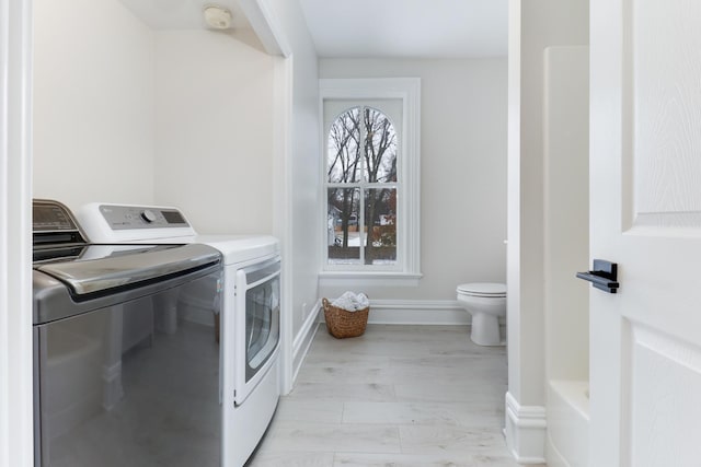 laundry room featuring light hardwood / wood-style flooring and washing machine and dryer