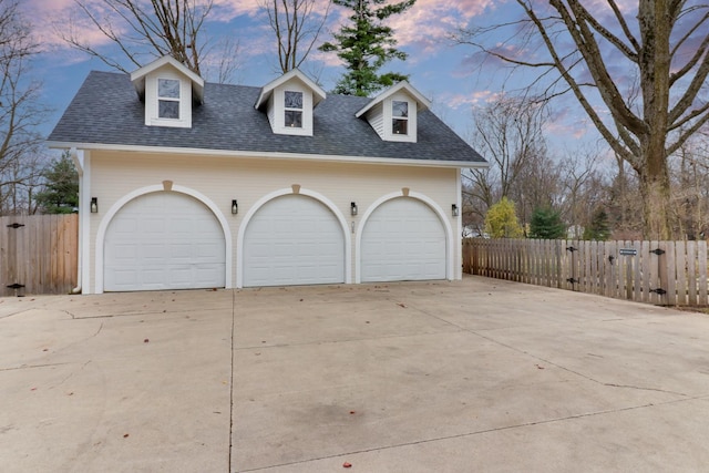 view of garage at dusk