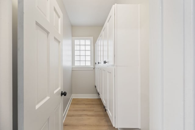 laundry area with light hardwood / wood-style floors