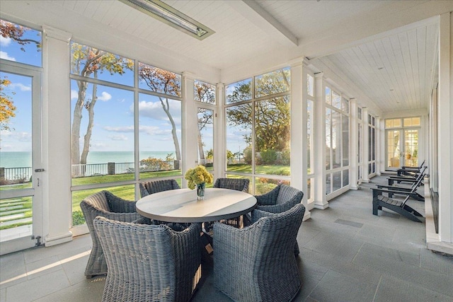 sunroom / solarium featuring a water view, beam ceiling, and wooden ceiling