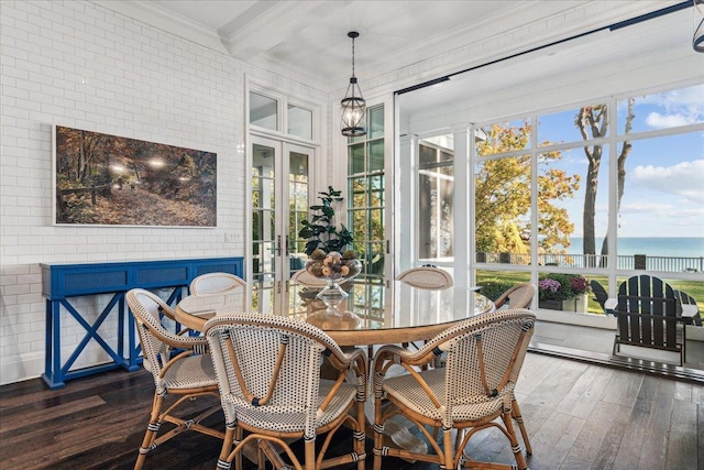 interior space with a water view, brick wall, crown molding, and dark hardwood / wood-style flooring