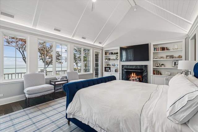 bedroom with hardwood / wood-style floors, beam ceiling, high vaulted ceiling, and a premium fireplace