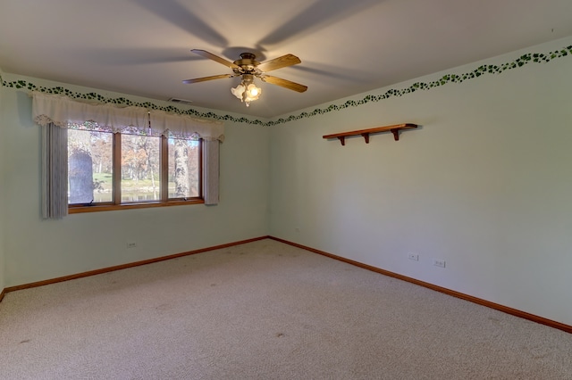 carpeted spare room with ceiling fan