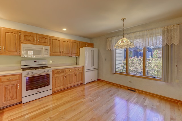 kitchen with light hardwood / wood-style floors, pendant lighting, and white appliances