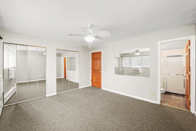 unfurnished bedroom with ensuite bathroom, dark colored carpet, a wall mounted AC, two closets, and a baseboard heating unit