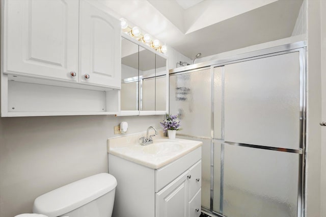 bathroom with vanity, a shower with door, and toilet