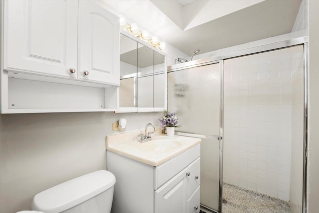 bathroom with vanity, a shower with shower door, and toilet