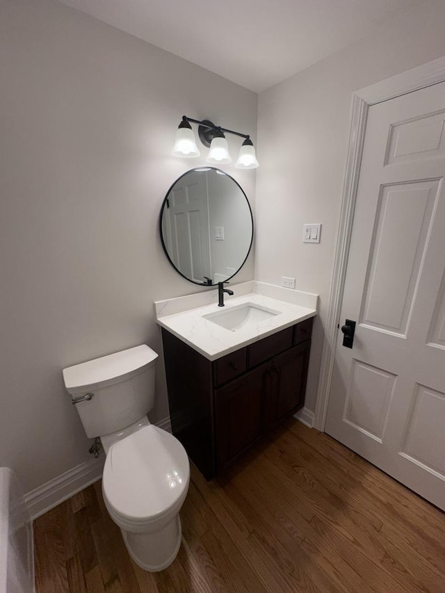 bathroom with vanity, toilet, and hardwood / wood-style floors