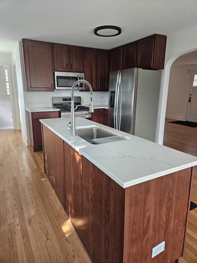 8646 S Nagle Ave, Burbank, IL 60459 - kitchen with an island with sink, light wood finished floors, stainless steel appliances, and arched walkways