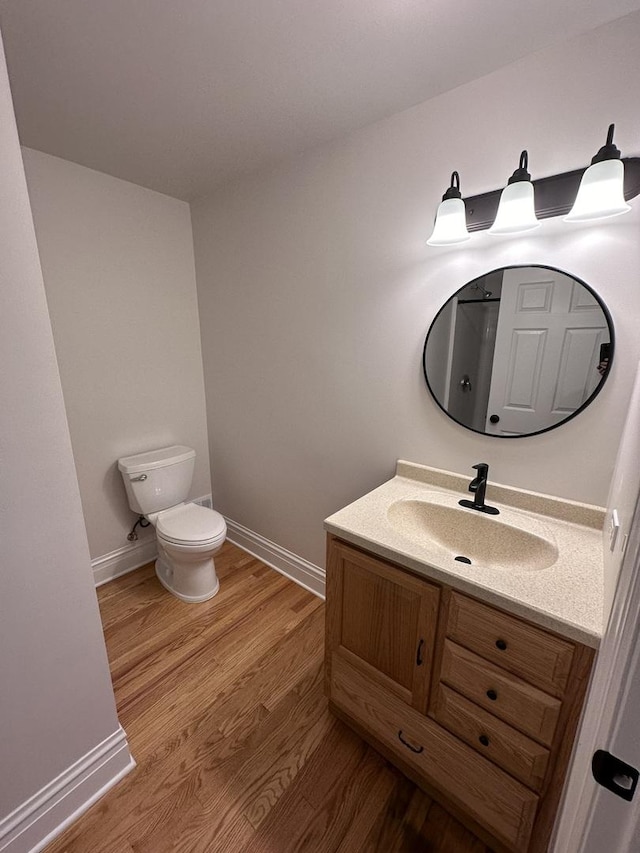 bathroom featuring vanity, toilet, and hardwood / wood-style floors