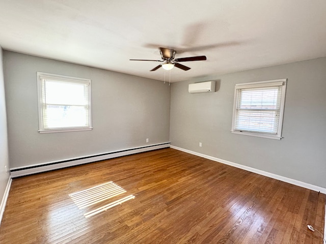 empty room featuring a baseboard heating unit, a wall mounted air conditioner, ceiling fan, and hardwood / wood-style flooring