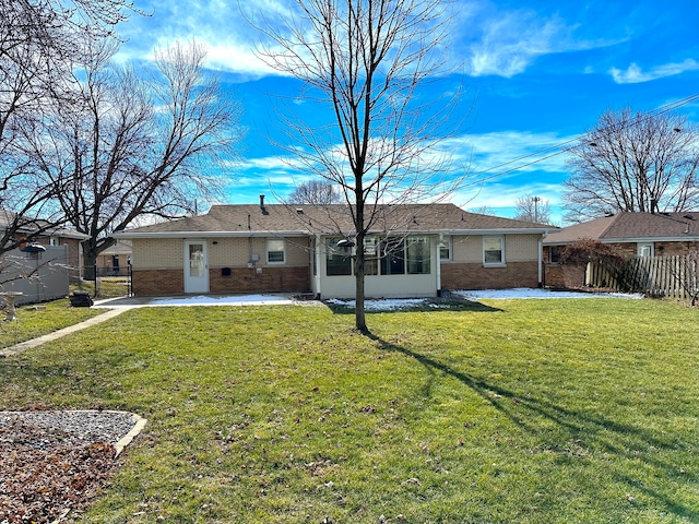 back of property with a sunroom and a lawn