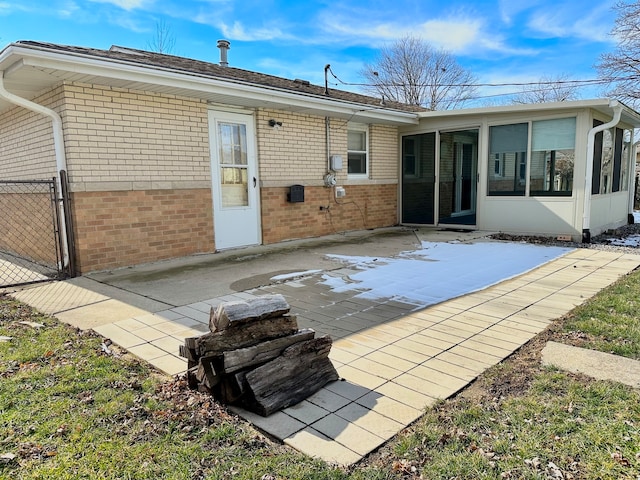 back of property featuring a sunroom and a patio