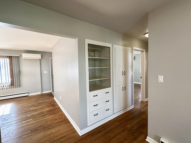 hall featuring dark hardwood / wood-style flooring, an AC wall unit, and baseboard heating