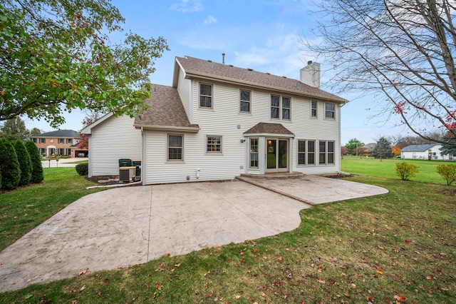 back of property featuring a lawn, central AC, and a patio area