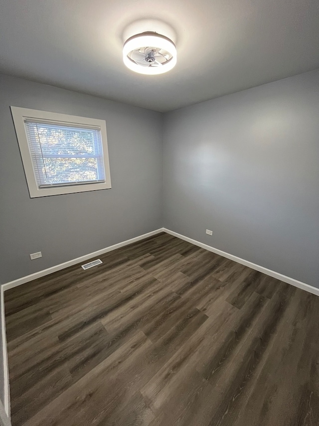 unfurnished room with dark hardwood / wood-style flooring