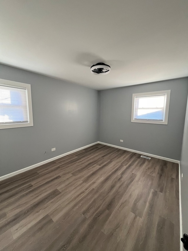 unfurnished room with dark wood-type flooring and a healthy amount of sunlight