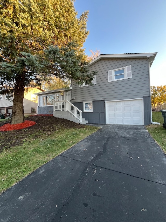 view of front of property with a garage and a yard