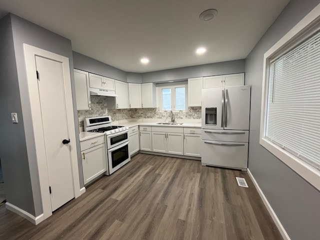 kitchen featuring white cabinetry, sink, range with two ovens, dark wood-type flooring, and fridge with ice dispenser