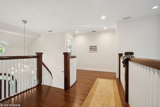 hall with dark wood-type flooring and crown molding