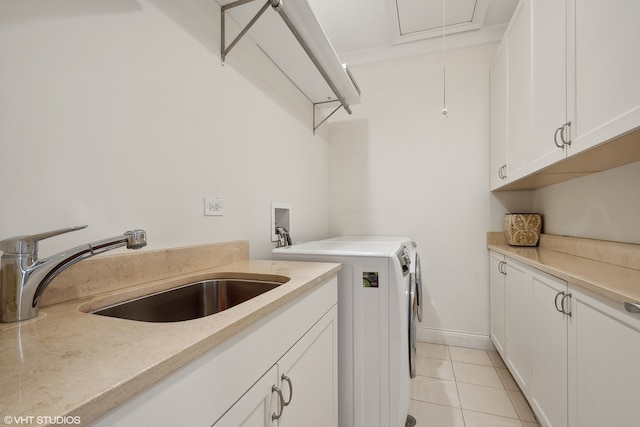 clothes washing area featuring sink, washer and clothes dryer, light tile patterned flooring, and cabinets