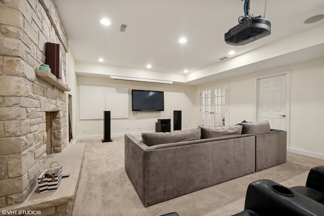 cinema with french doors, light carpet, and a fireplace