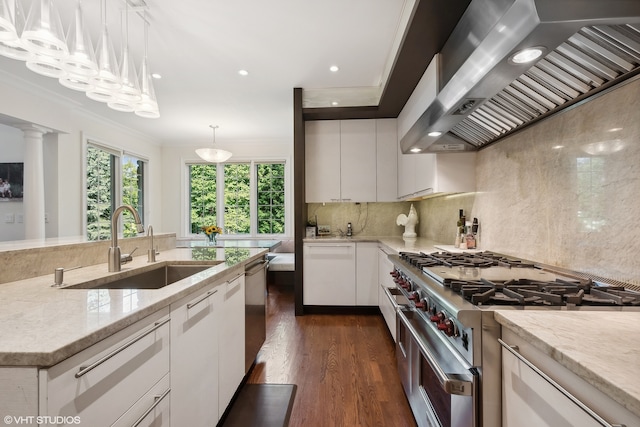 kitchen featuring stainless steel appliances, wall chimney exhaust hood, decorative light fixtures, white cabinets, and dark wood-type flooring