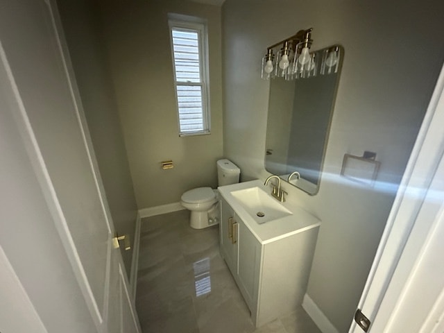 bathroom with toilet, vanity, and tile patterned floors