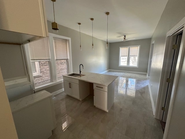 kitchen featuring sink, white cabinetry, decorative light fixtures, and ceiling fan