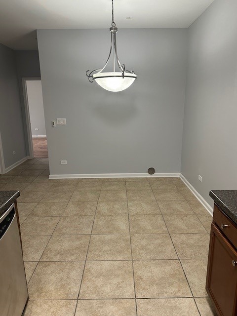 unfurnished dining area with light tile patterned flooring