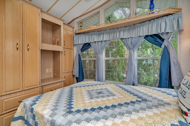 bedroom featuring multiple windows, a textured ceiling, and vaulted ceiling