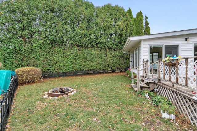 view of yard with a wooden deck and an outdoor fire pit