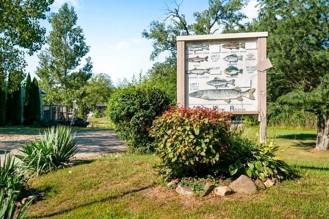 community / neighborhood sign featuring a yard