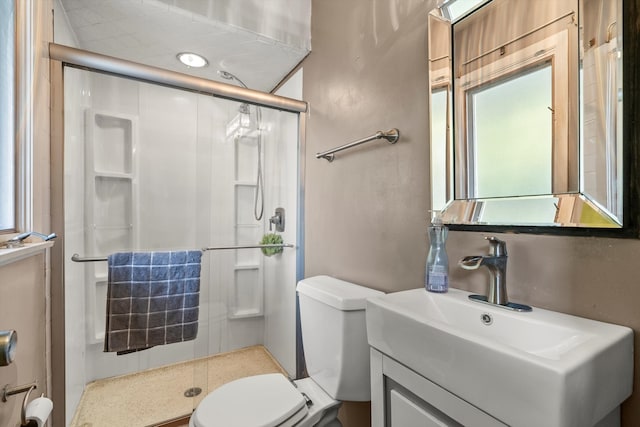 bathroom with vanity, a shower with shower door, and toilet