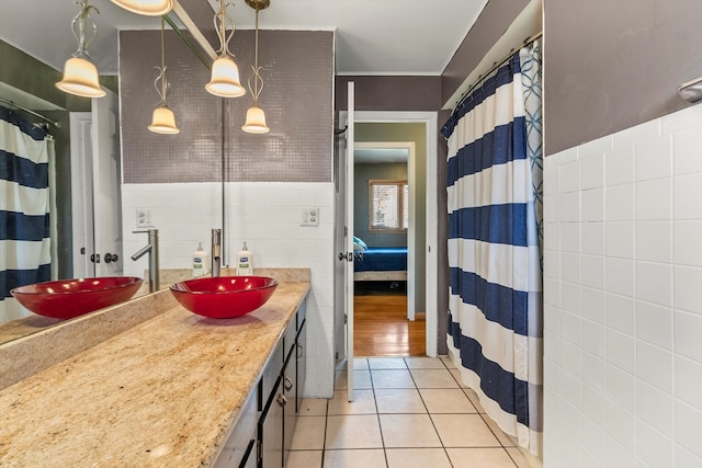 bathroom featuring vanity, crown molding, tile patterned floors, and tile walls