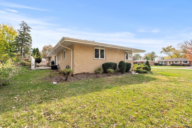 view of side of home with a yard