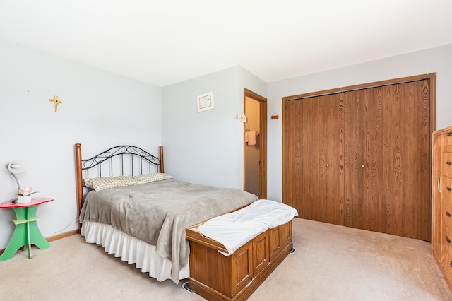 bedroom with light carpet and a closet