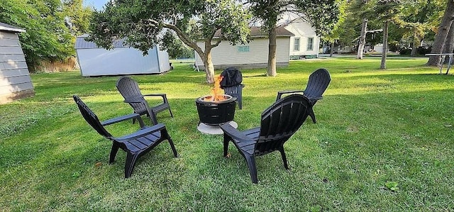 surrounding community with a yard and a fire pit