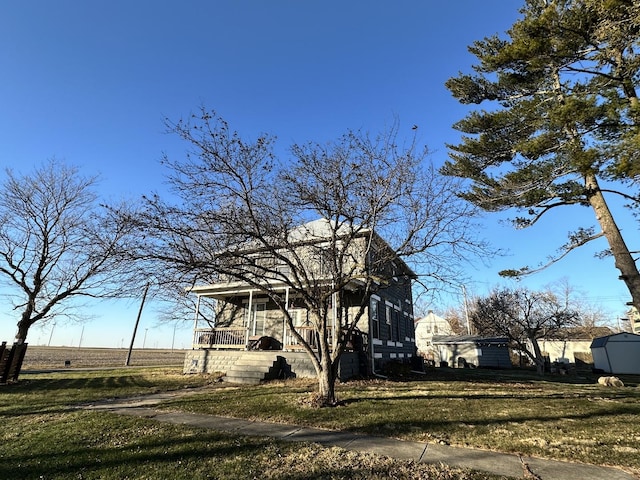 view of home's exterior featuring a lawn and covered porch