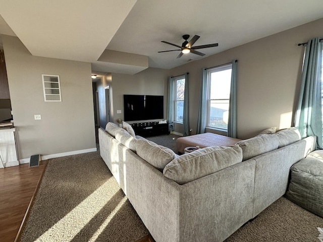 living room featuring ceiling fan and dark wood-type flooring