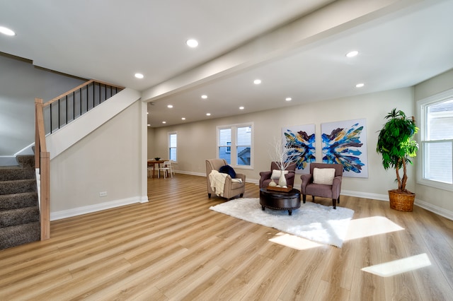 sitting room featuring light hardwood / wood-style flooring, beam ceiling, and a wealth of natural light