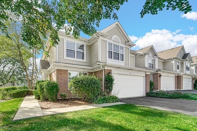 townhome / multi-family property with a front lawn and a garage