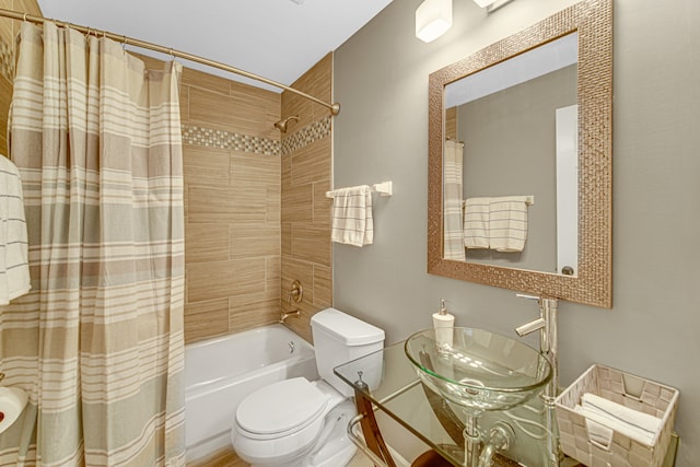 full bathroom featuring toilet, shower / bathtub combination with curtain, and sink