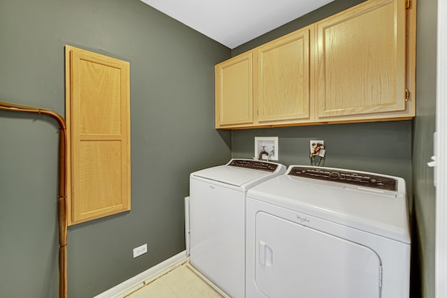 clothes washing area featuring cabinets and washer and clothes dryer