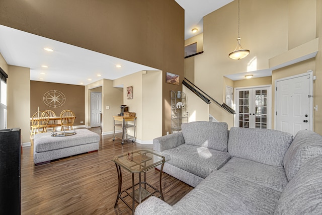 living room with french doors, dark hardwood / wood-style flooring, plenty of natural light, and a high ceiling