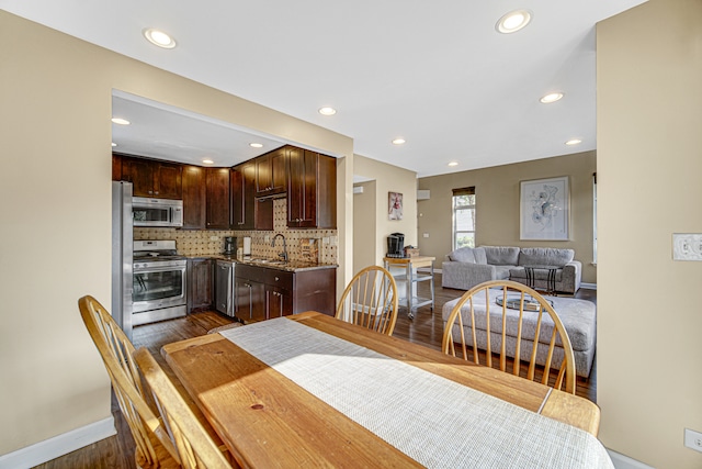 dining space featuring dark wood-type flooring and sink