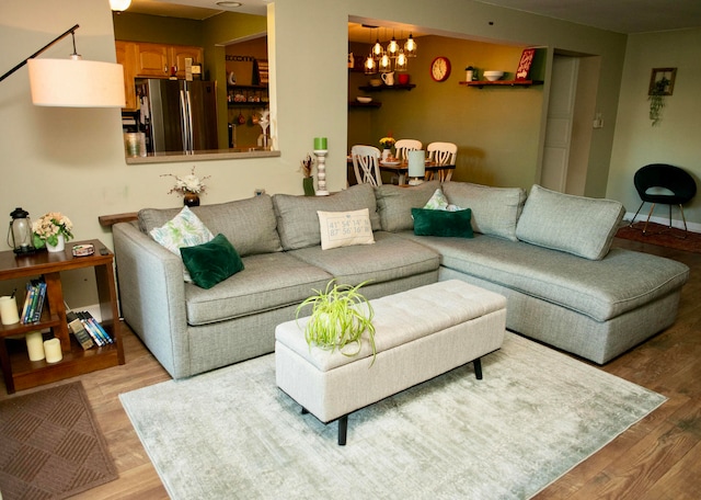 living room featuring a chandelier and light hardwood / wood-style flooring