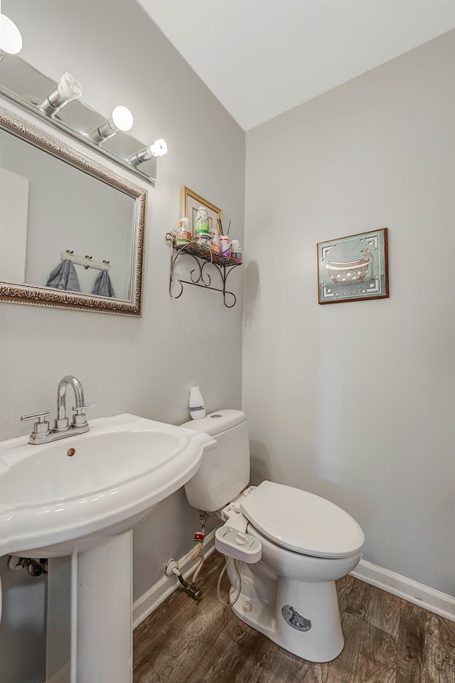 bathroom with toilet, hardwood / wood-style flooring, and sink