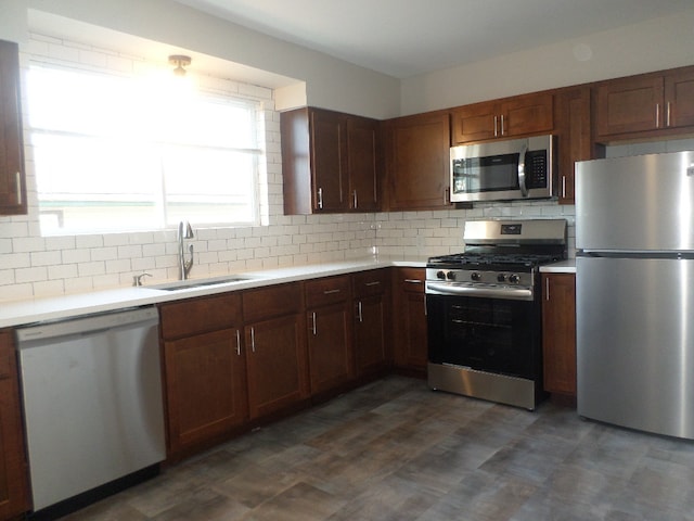 kitchen featuring backsplash, appliances with stainless steel finishes, and sink