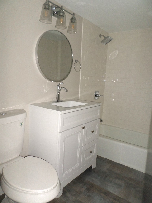 full bathroom with vanity, toilet, wood-type flooring, and tiled shower / bath